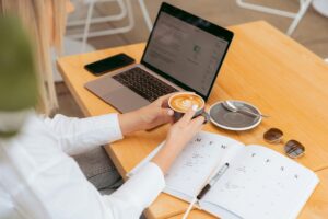 Girl having a coffee while working on her laptop