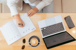 A laptop on table with a cup of coffee