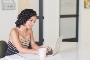 Girl sitting, using laptop.